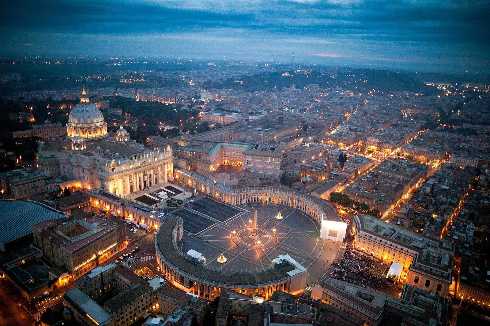 Piazza San Pietro vista dall'alto al crepuscolo, gremita di fedeli